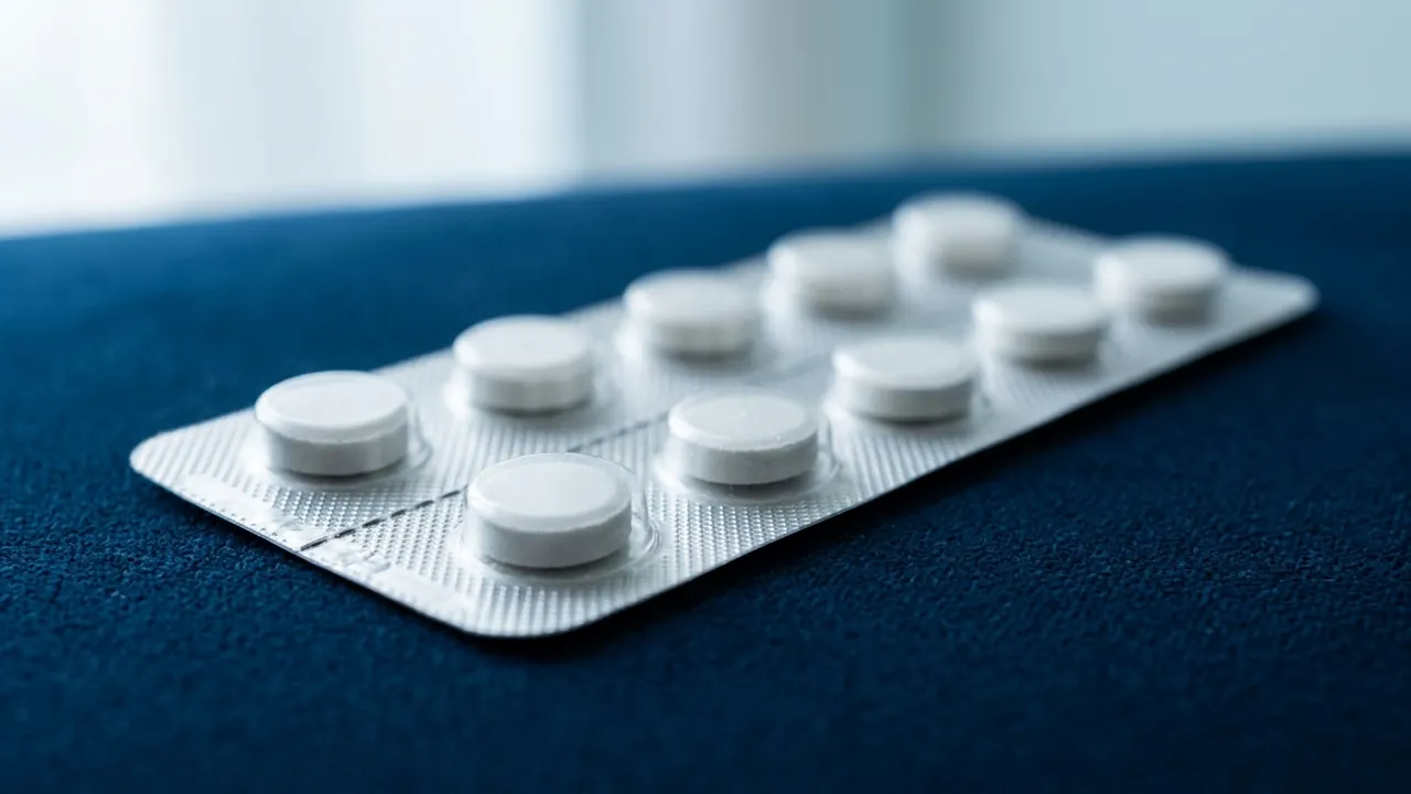 A silver blister pack of plain white tablets lying at a diagonal on a deep-blue surface — Transplant vs medication